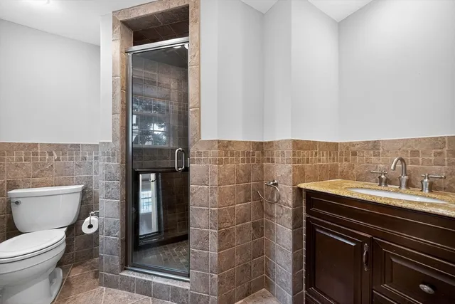 a bathroom with a sink a toilet and shower