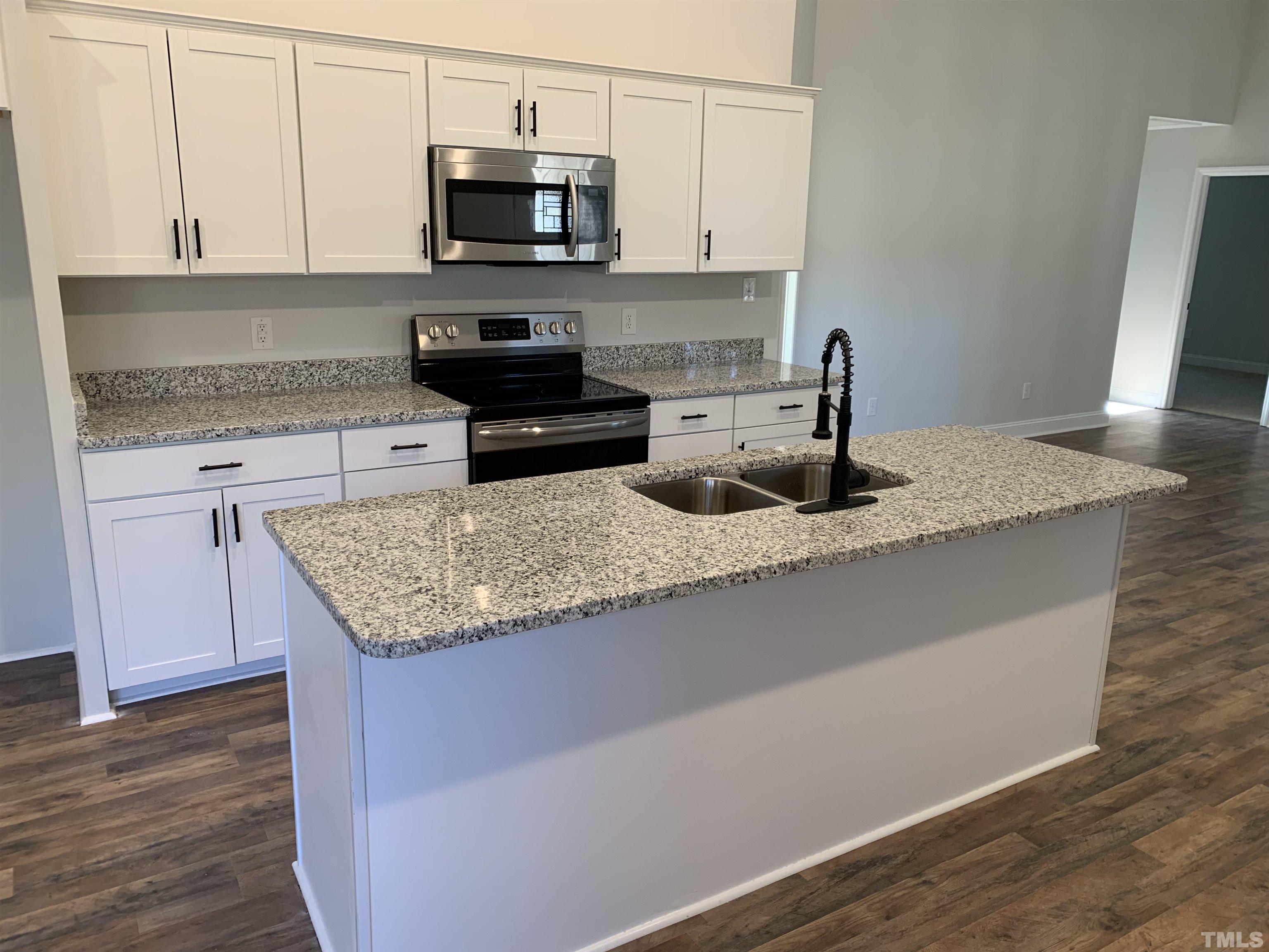 337 Chisenhall Road Angier, NC 27501 - Photo 2 of 7 a kitchen with granite countertop a sink a stove and a microwave