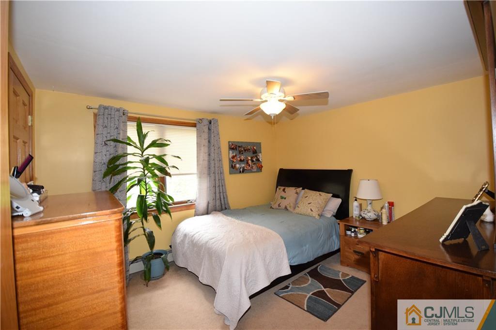 65 Warrenville Road Middlesex, NJ 08846 - Photo 21 of 22 a bedroom with a bed lamps and a large window