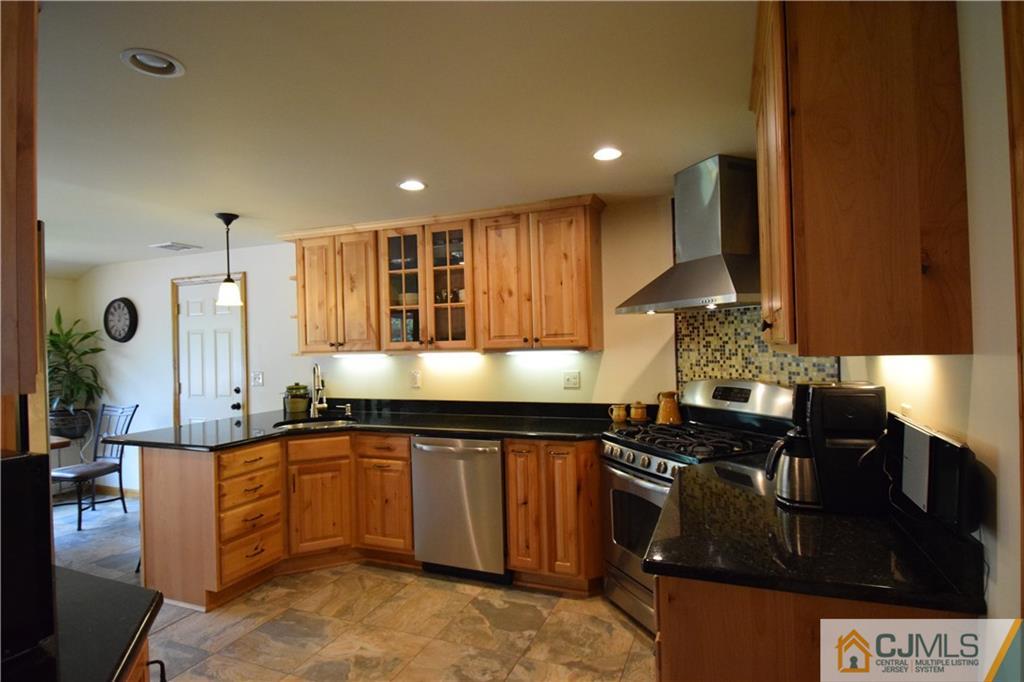 65 Warrenville Road Middlesex, NJ 08846 - Photo 6 of 22 a kitchen with stainless steel appliances granite countertop a sink a stove and a wooden cabinets