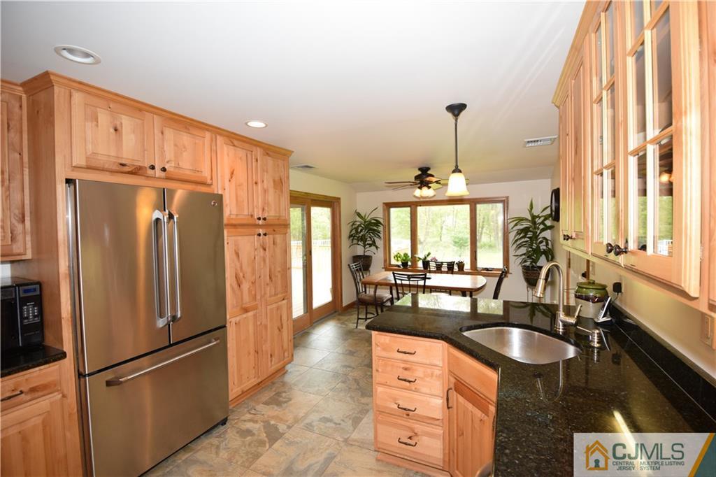 65 Warrenville Road Middlesex, NJ 08846 - Photo 7 of 22 a kitchen with stainless steel appliances granite countertop a refrigerator a sink and a stove with wooden floor