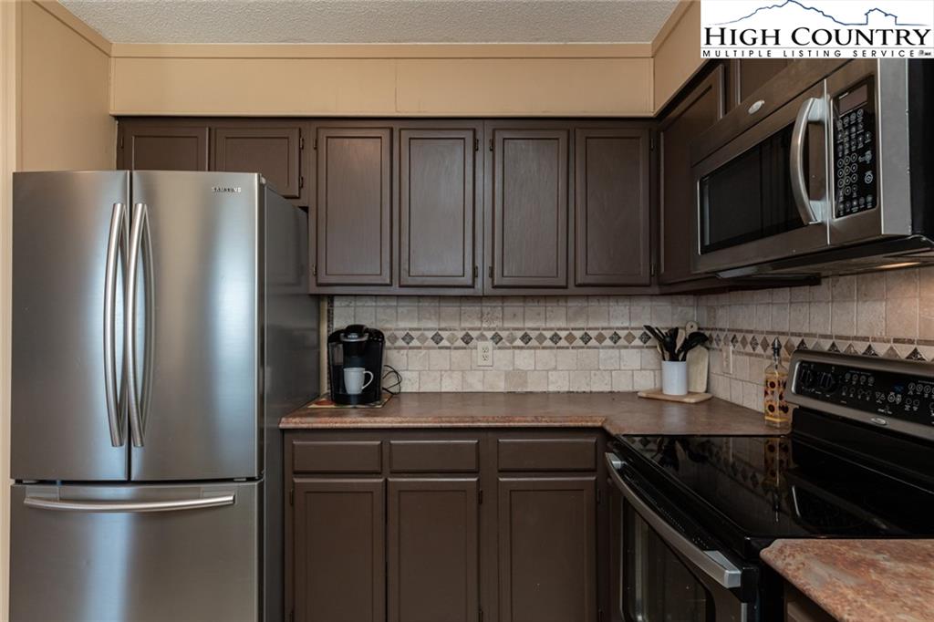 301 Pinnacle Inn Road, Unit 2316 Beech Mountain, NC 28604 - Photo 21 of 50 a kitchen with stainless steel appliances granite countertop a refrigerator stove and microwave