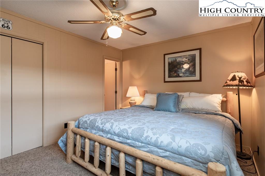 301 Pinnacle Inn Road, Unit 2316 Beech Mountain, NC 28604 - Photo 25 of 50 a bedroom with a bed and a chandelier
