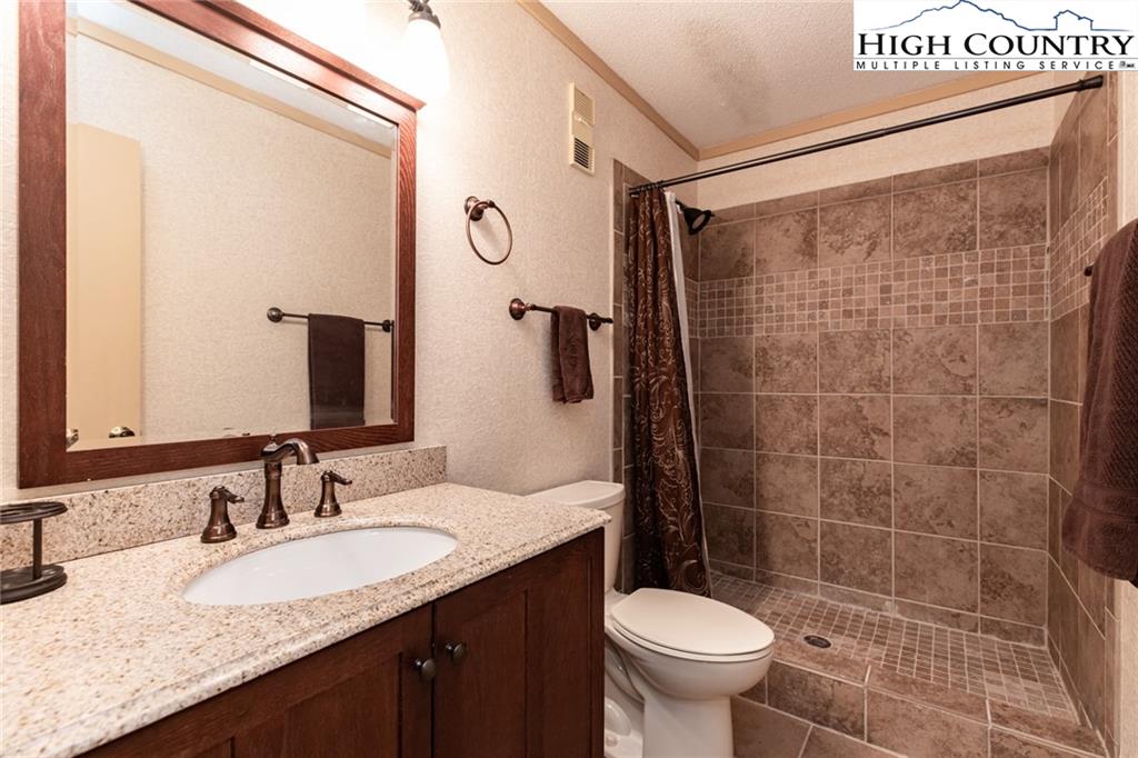 301 Pinnacle Inn Road, Unit 2316 Beech Mountain, NC 28604 - Photo 31 of 50 a bathroom with a granite countertop sink toilet and shower