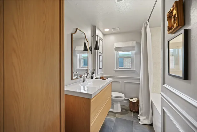 a bathroom with a double vanity sink toilet and mirror