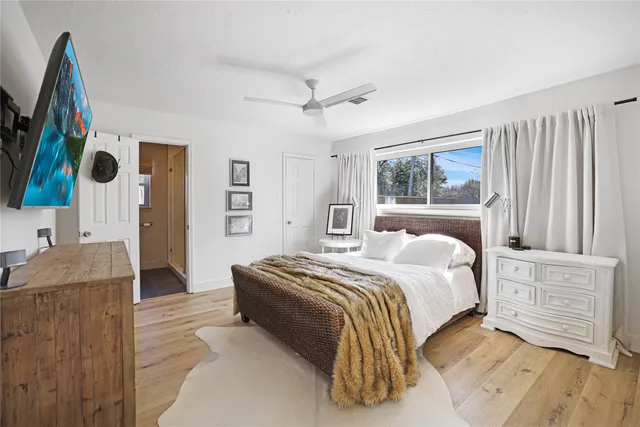 a spacious bedroom with a bed and a flat screen television