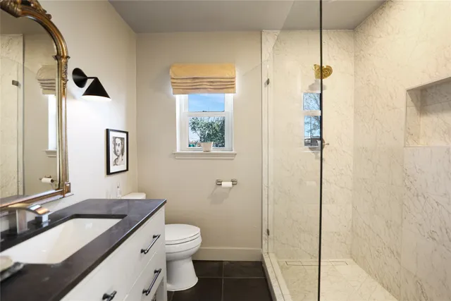 a bathroom with a granite countertop sink toilet and shower