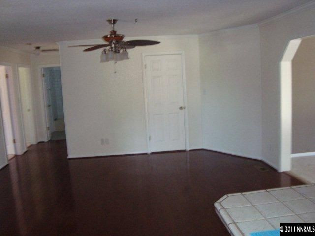 303 Rice Road Fallon, NV 89406 - Photo 4 of 13 an empty room with wooden floor a ceiling fan and a window