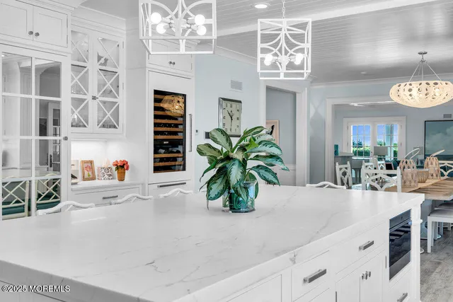 a view of a dining room with furniture a chandelier and wooden floor