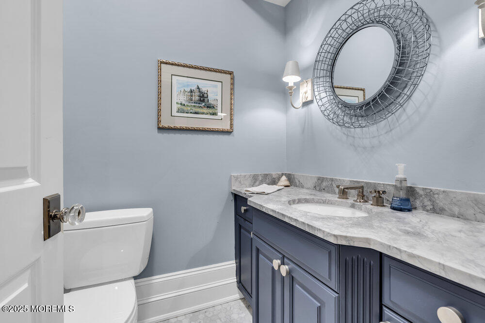 15 Madison Avenue Spring Lake, NJ 07762 - Photo 52 of 53 a bathroom with a granite countertop toilet a sink and a mirror