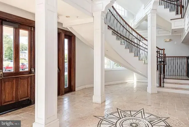 a view of a hallway with wooden floor and staircase