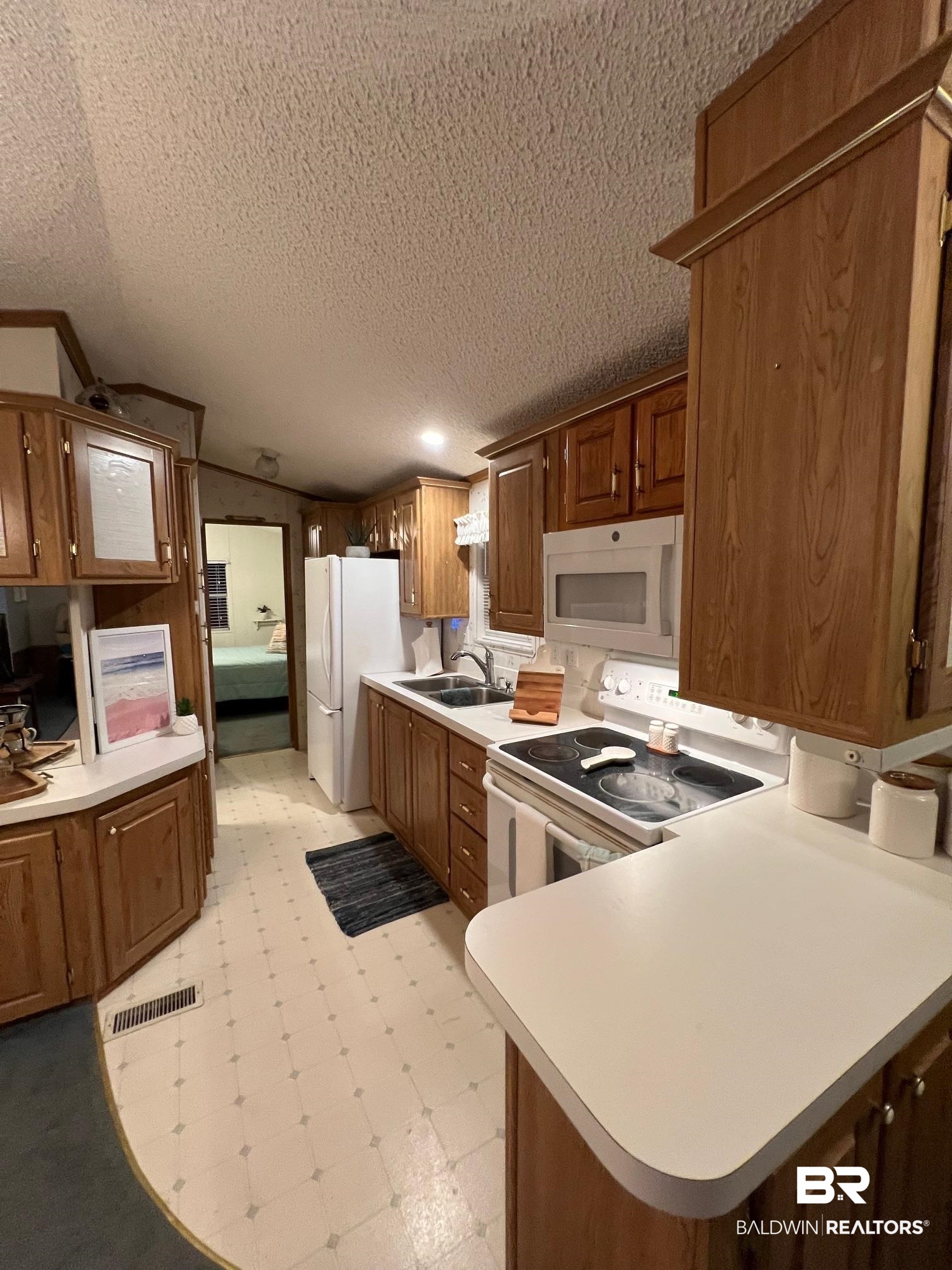 518 Elberta Loop Lillian, AL 36549 - Photo 8 of 38 Kitchen featuring light countertops, a sink, light floors, and white appliances