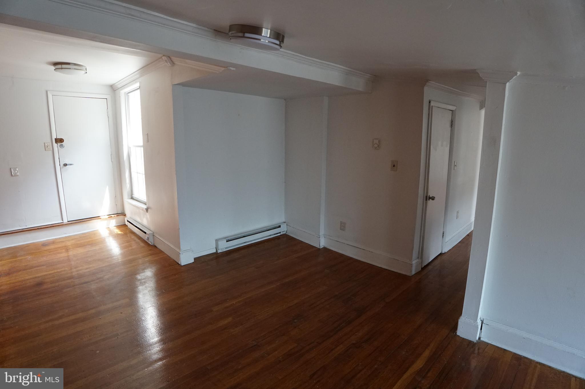 802 Cathedral Street, Unit 4 Baltimore, MD 21201 - Photo 10 of 15 an empty room with wooden floor and entrance