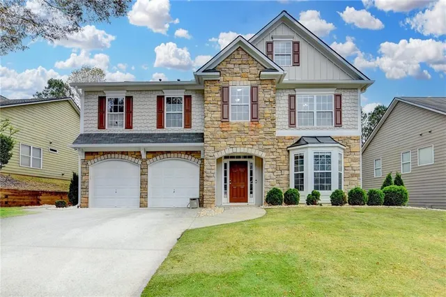 a front view of a house with a yard and garage