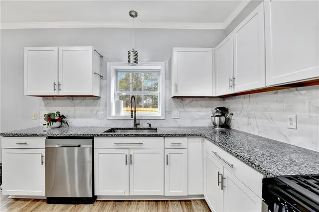 a kitchen with granite countertop a sink stove and cabinets