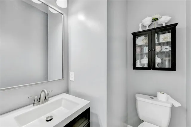 a bathroom with a toilet sink and mirror