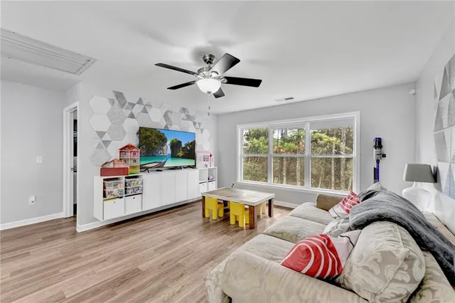 a living room with furniture a flat screen tv and a large window