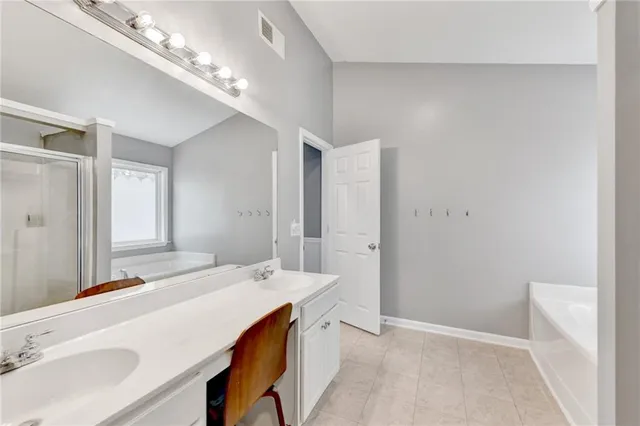 a spacious bathroom with a sink a large mirror and shower