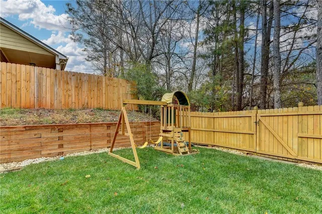 a view of backyard with wooden fence and a large tree