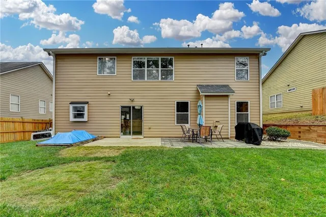a backyard of a house with table and chairs