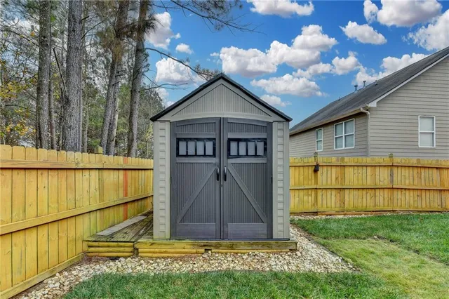 a view of backyard with wooden fence