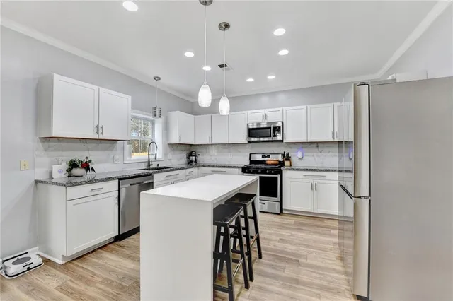 a kitchen with a sink a counter top space stainless steel appliances and cabinets