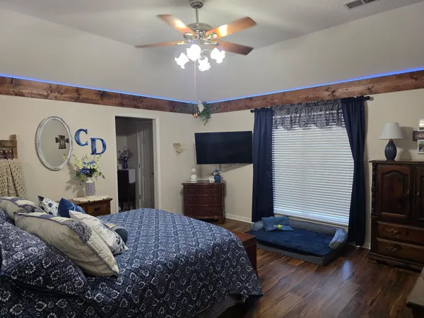 a bedroom with a bed and a flat tv screen on the dresser