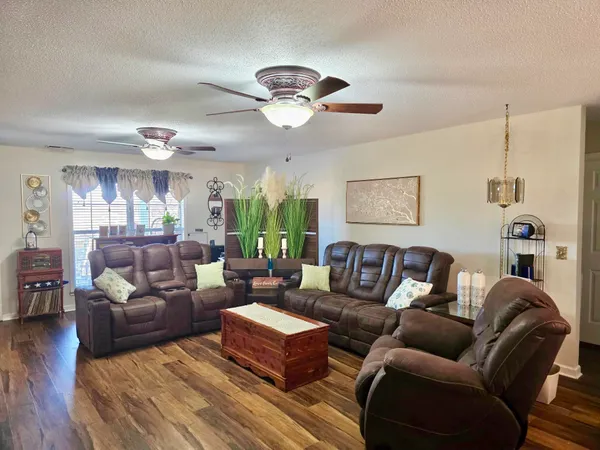 a living room with furniture a ceiling fan and a window