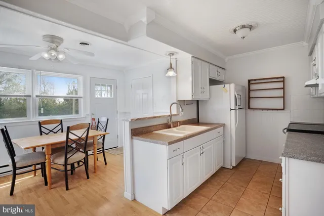a kitchen with stainless steel appliances granite countertop furniture and a wooden floor