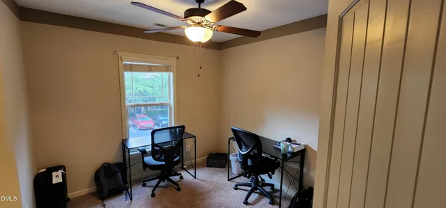a view of a workspace with furniture and a window