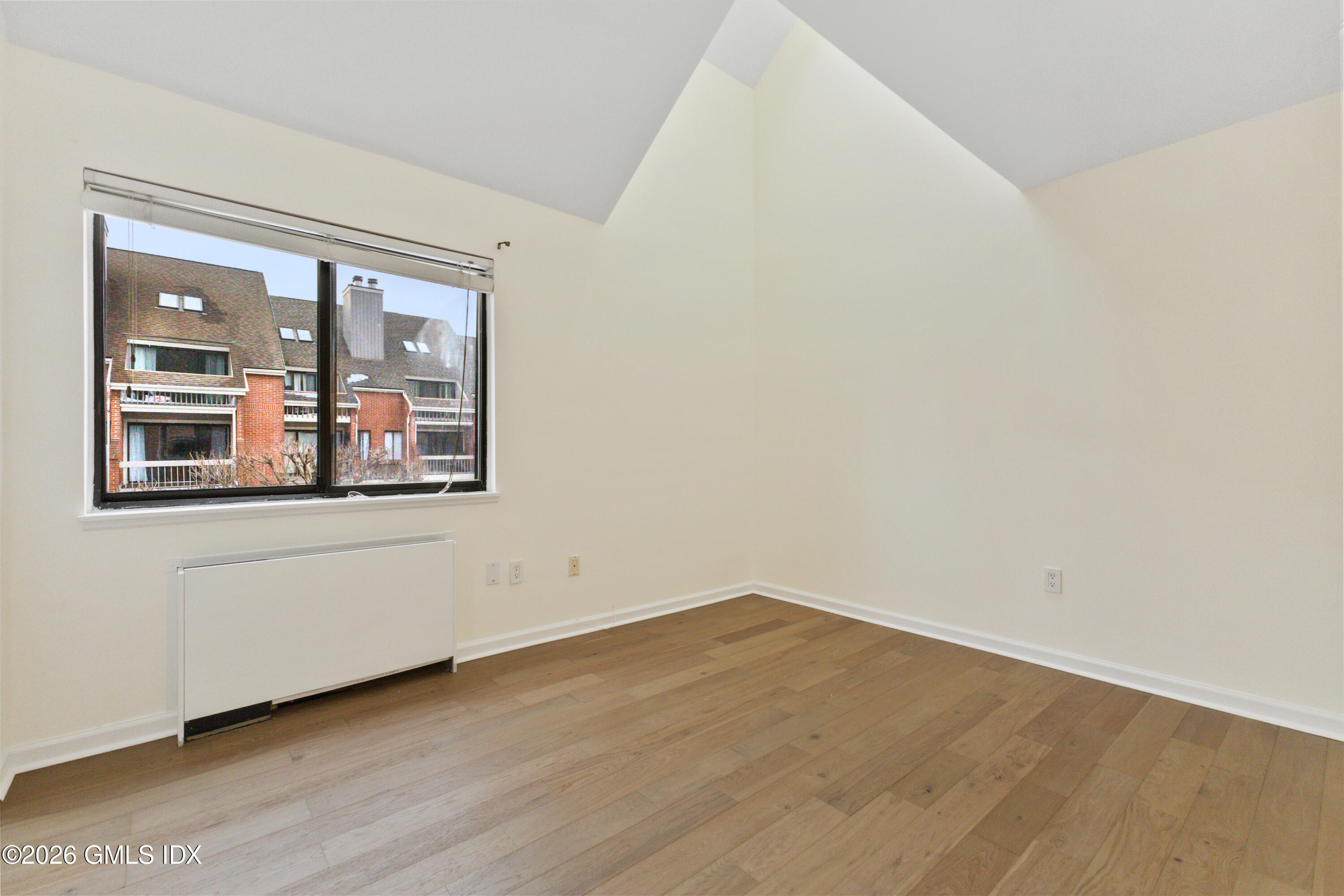 15 River Road, Unit 210 Cos Cob, CT 06807 - Photo 19 of 23 an empty room with wooden floor and windows