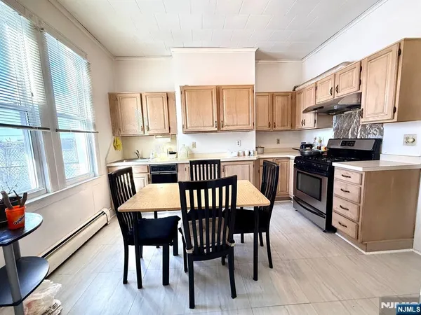 a kitchen with a table chairs microwave and cabinets