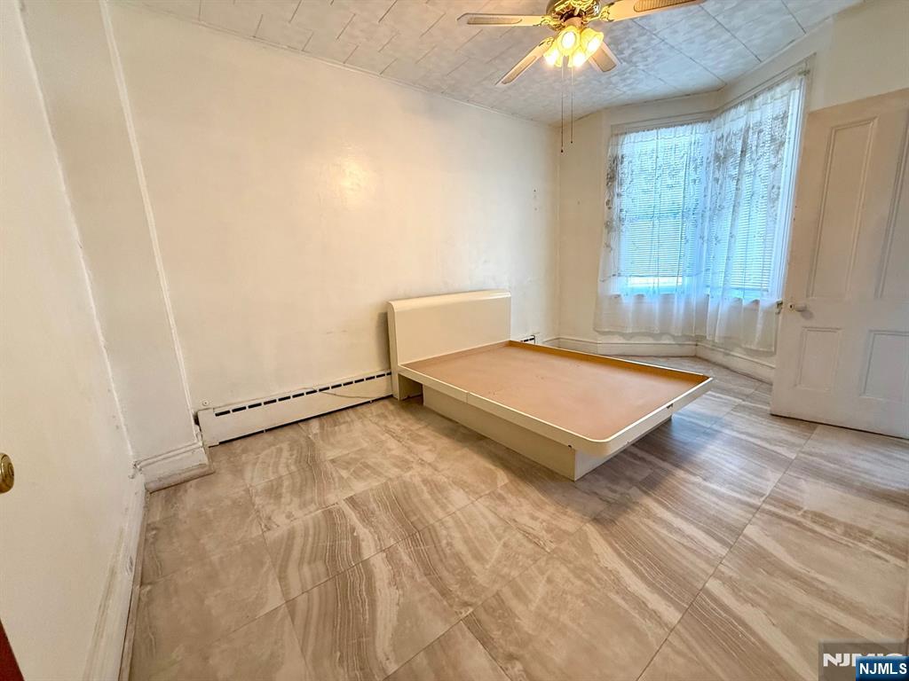 405 7th Street Harrison, NJ 07029 - Photo 9 of 21 a living room with a bed and a chandelier