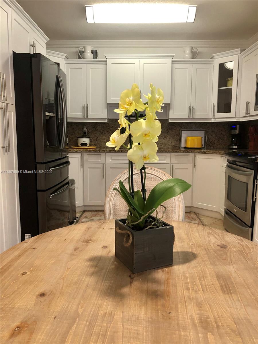 6450 Southwest 19th Street West Miami, FL 33155 - Photo 29 of 42 a kitchen with stainless steel appliances kitchen island granite countertop a refrigerator a stove a sink a counter space and cabinets