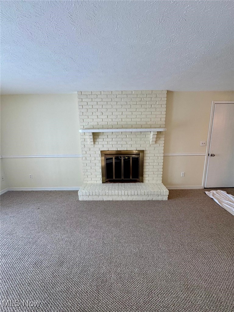 17073 Drake Road Strongsville, OH 44136 - Photo 8 of 50 Unfurnished living room with a fireplace, carpet flooring, and a textured ceiling
