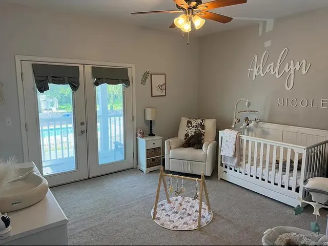 a bedroom with a bed and a flat tv screen on dresser