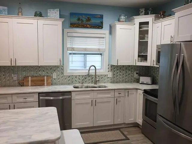 a kitchen with white cabinets and stainless steel appliances