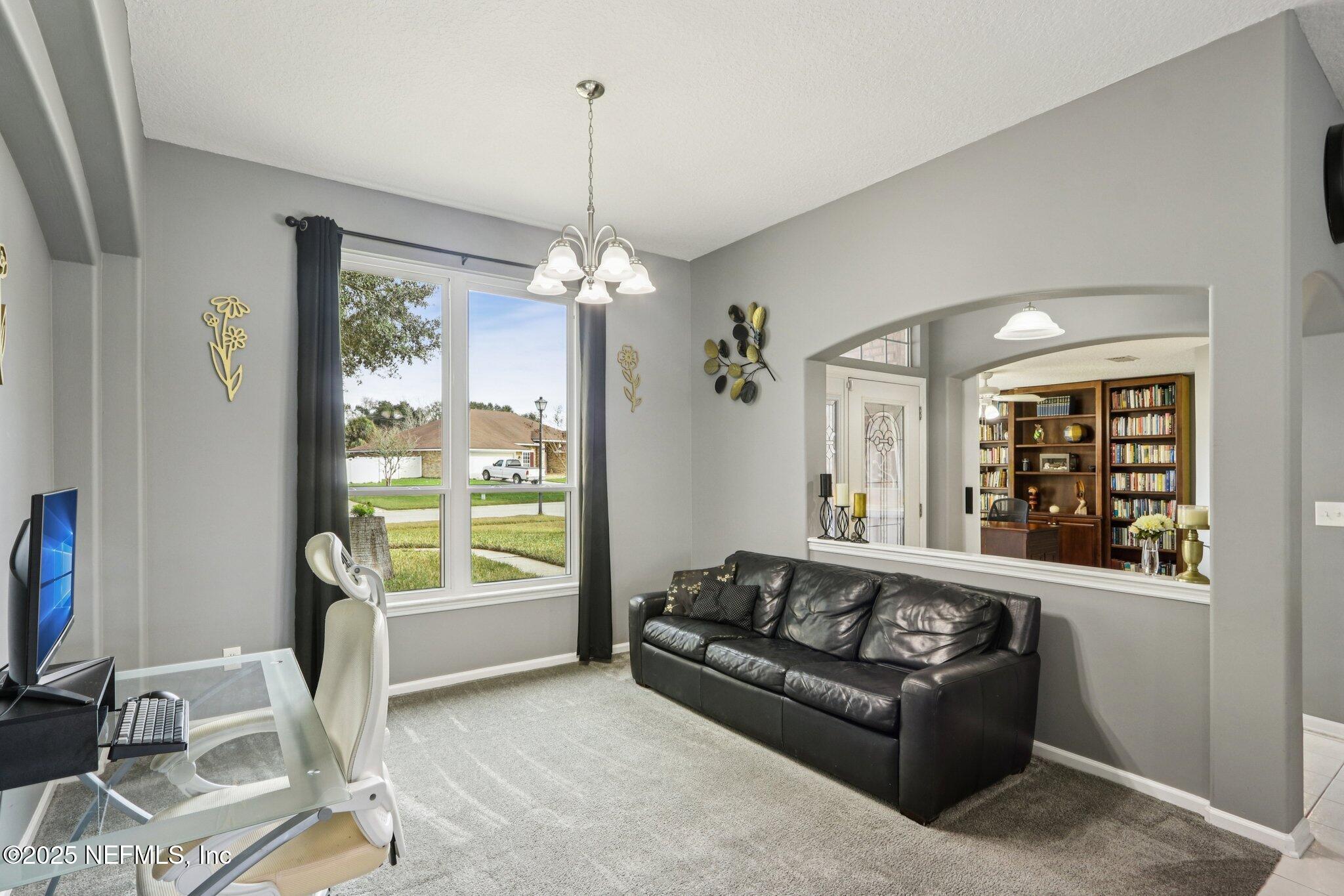 2390 Mallory Hills Road Jacksonville, FL 32221 - Photo 11 of 42 a living room with furniture and a chandelier