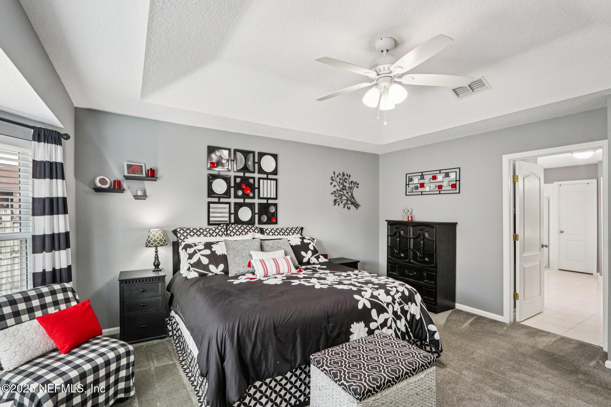 2390 Mallory Hills Road Jacksonville, FL 32221 - Photo 12 of 42 a bedroom with a bed and a chandelier