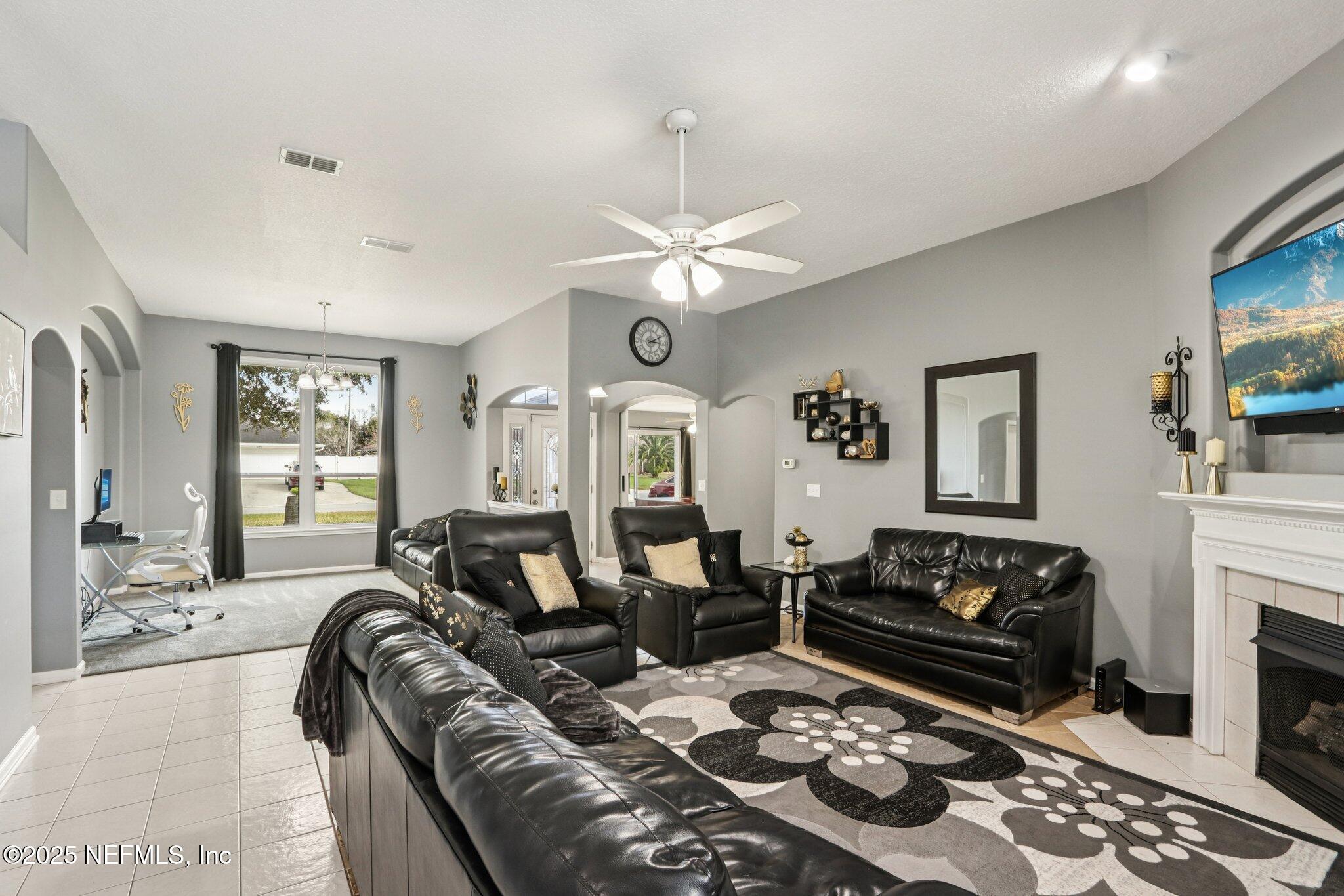 2390 Mallory Hills Road Jacksonville, FL 32221 - Photo 18 of 42 a living room with furniture a fireplace and a flat screen tv