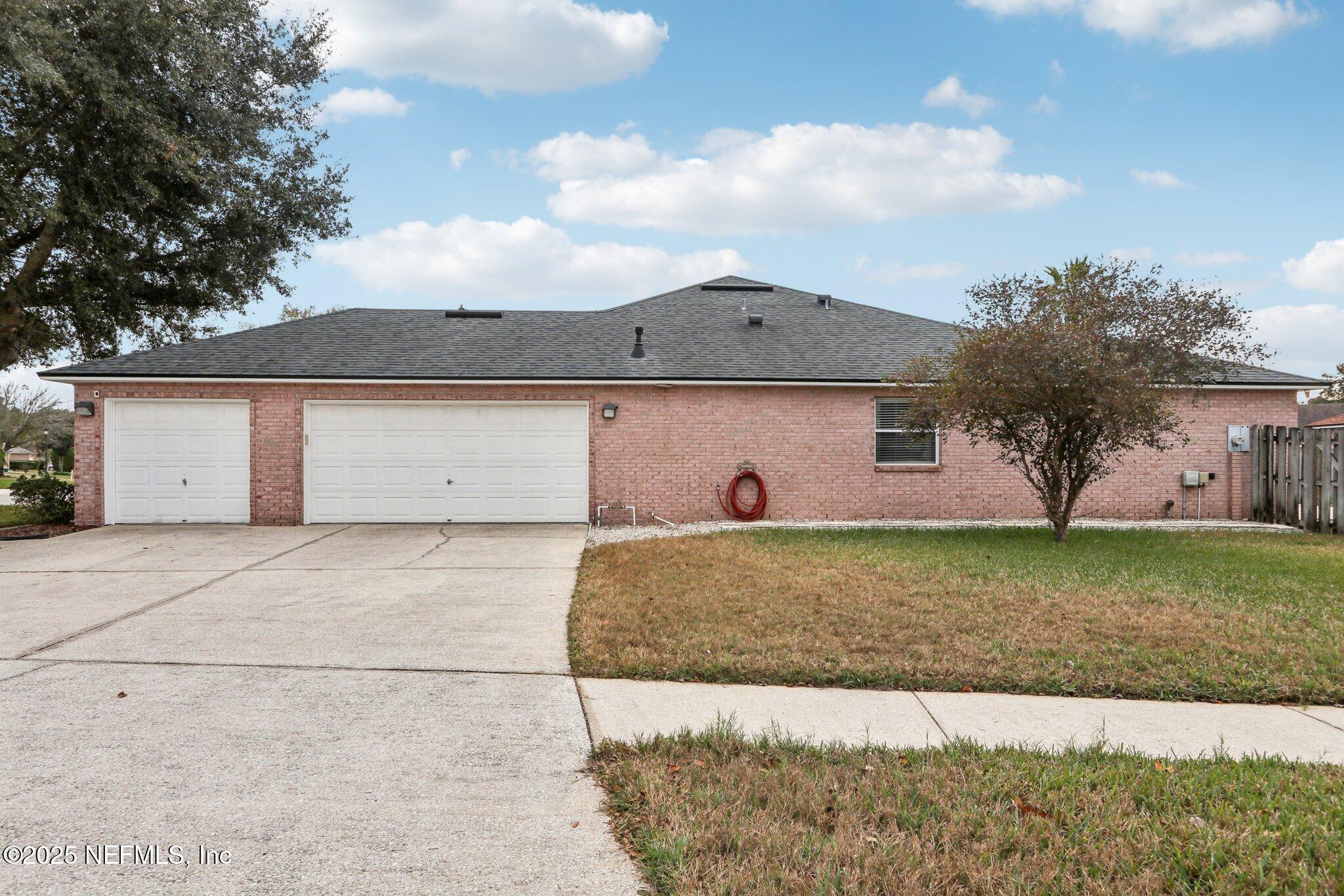 2390 Mallory Hills Road Jacksonville, FL 32221 - Photo 4 of 42 a front view of a house with a yard and garage