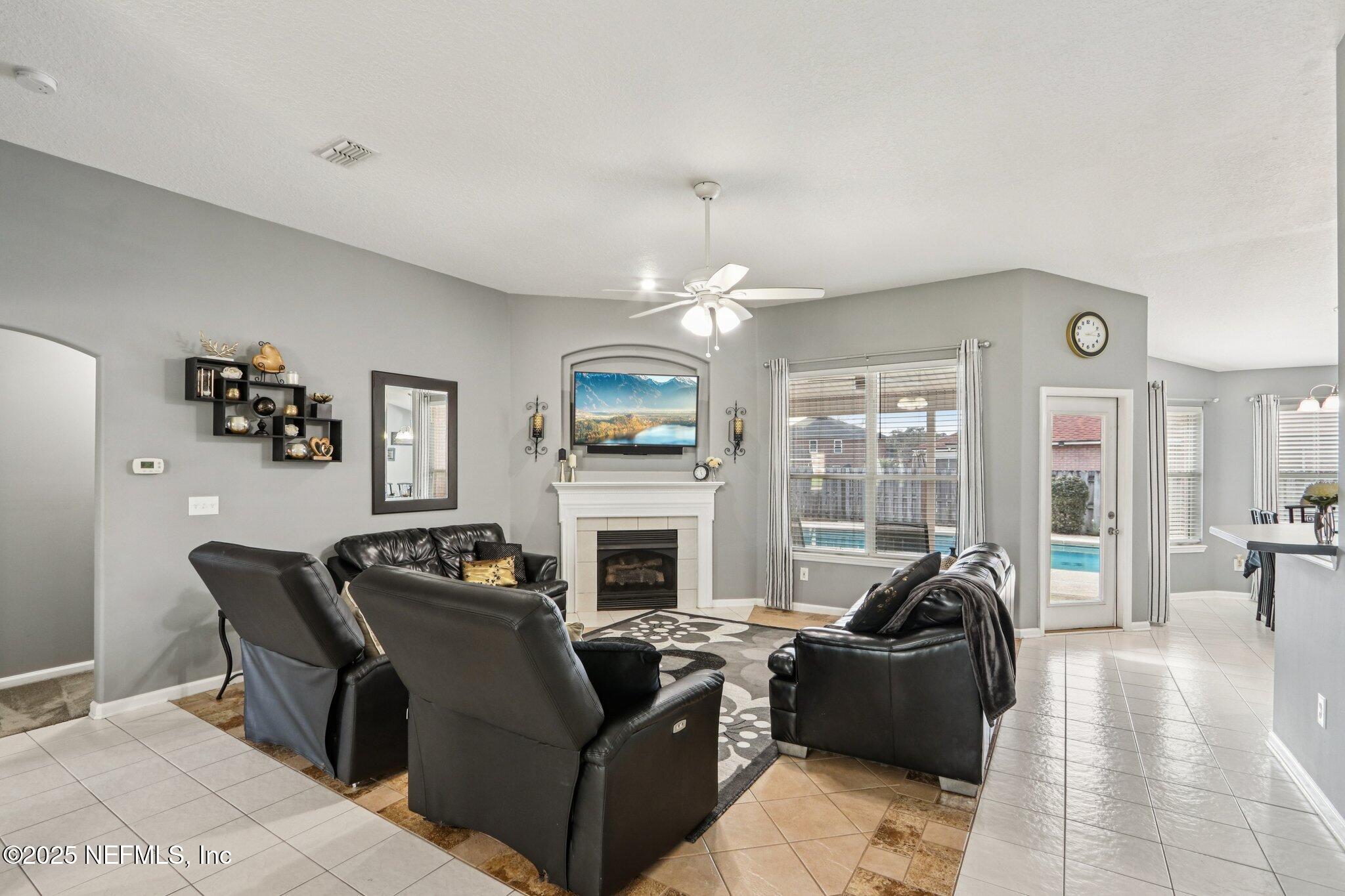 2390 Mallory Hills Road Jacksonville, FL 32221 - Photo 6 of 42 a living room with furniture a fireplace and a flat screen tv