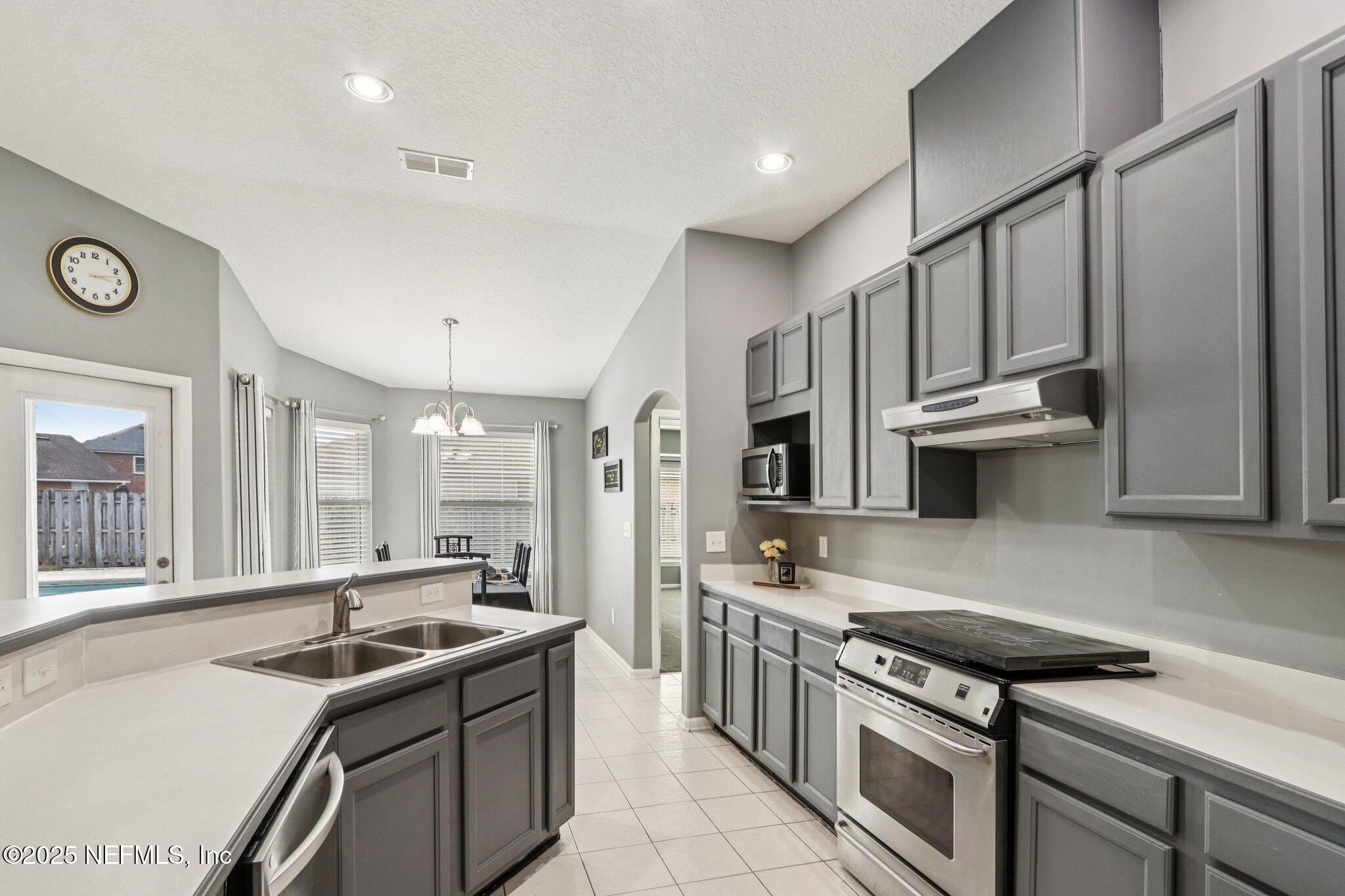 2390 Mallory Hills Road Jacksonville, FL 32221 - Photo 8 of 42 a kitchen with stainless steel appliances granite countertop a sink stove and cabinets