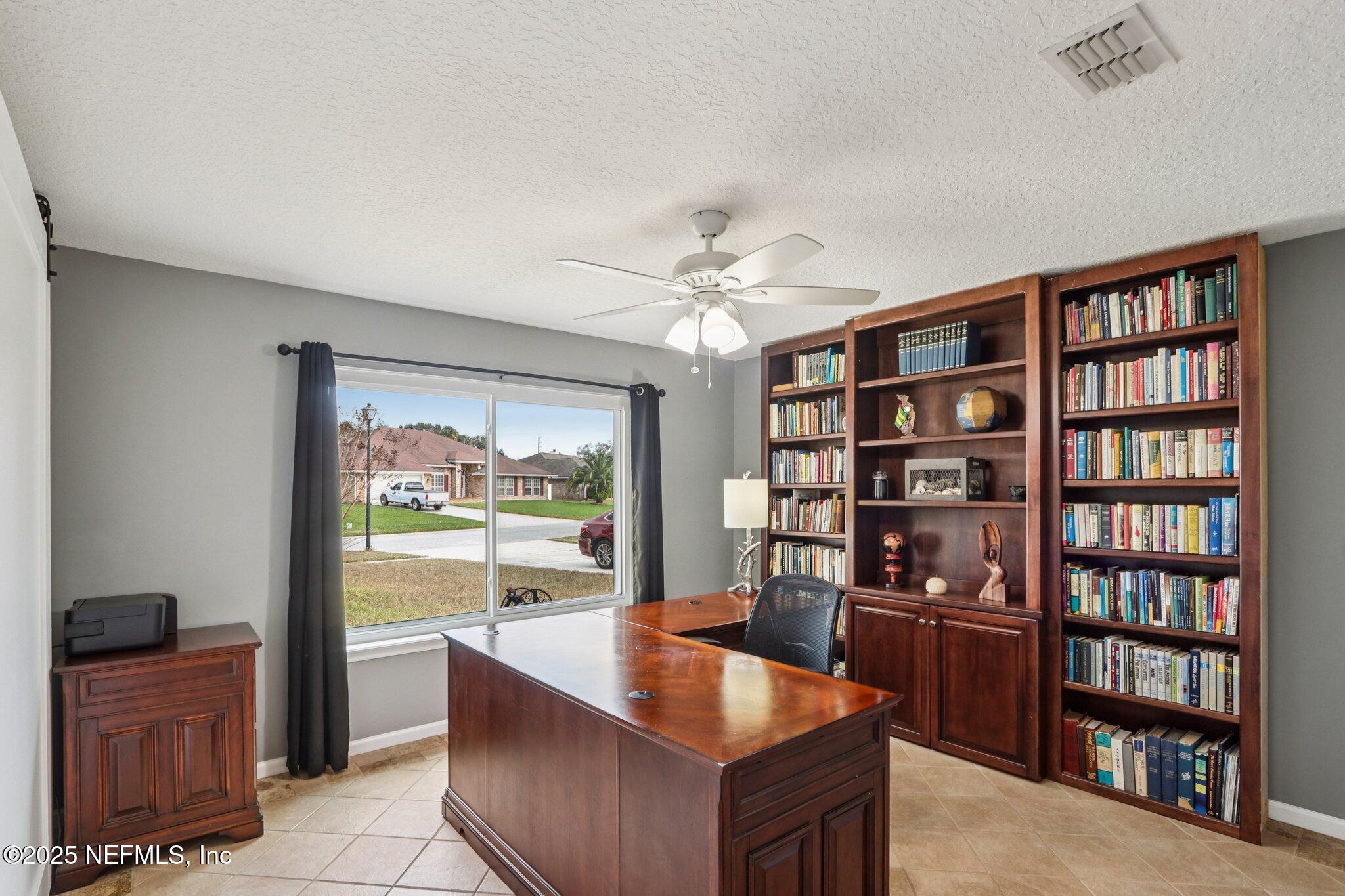 2390 Mallory Hills Road Jacksonville, FL 32221 - Photo 10 of 42 a living room with furniture and a book shelf