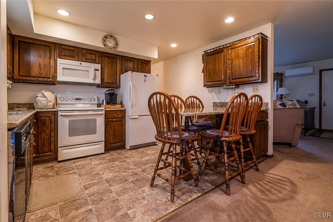 179 Kemmerer Road Nazareth, PA 18064 - Photo 20 of 38 a kitchen with stainless steel appliances kitchen island granite countertop a stove top oven a sink a dining table and chairs with wooden floor