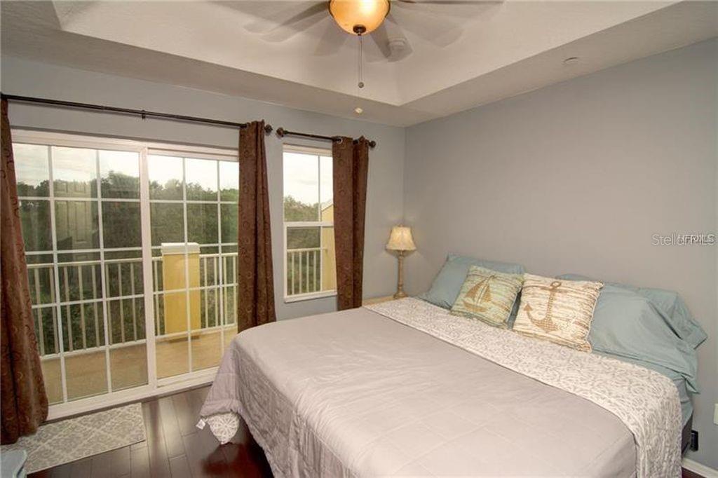 8946 White Sage Loop Lakewood Ranch, FL 34202 - Photo 25 of 36 a bedroom with a large bed and a chandelier