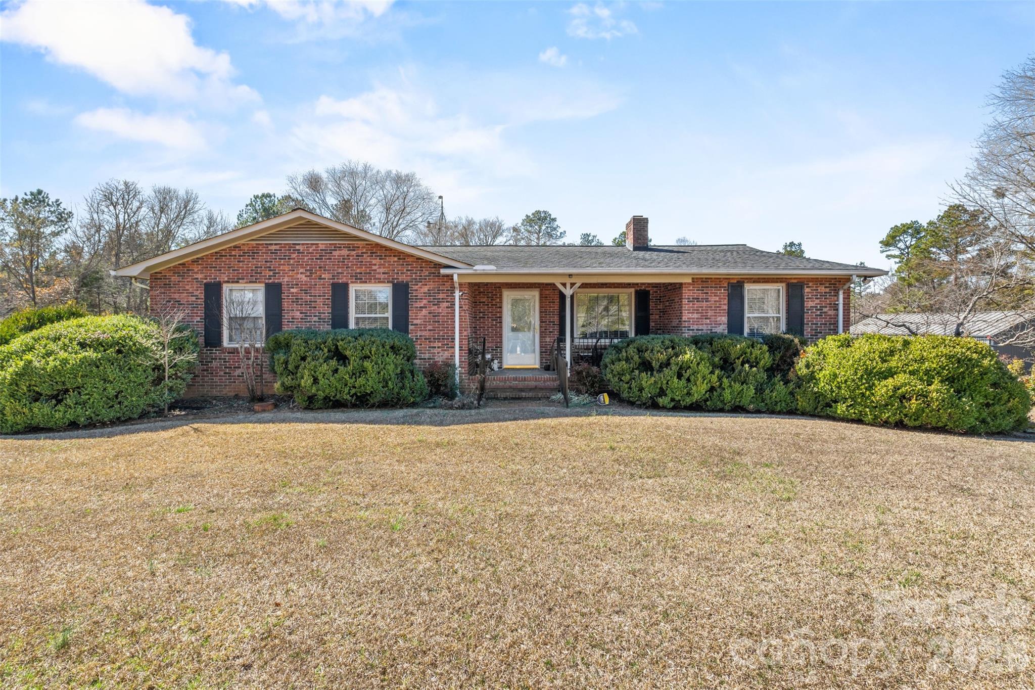 a front view of a house with a yard and trees