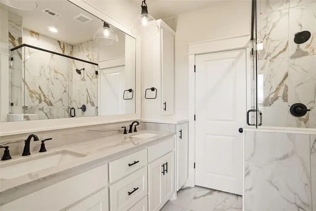 a bathroom with a granite countertop sink mirror and shower