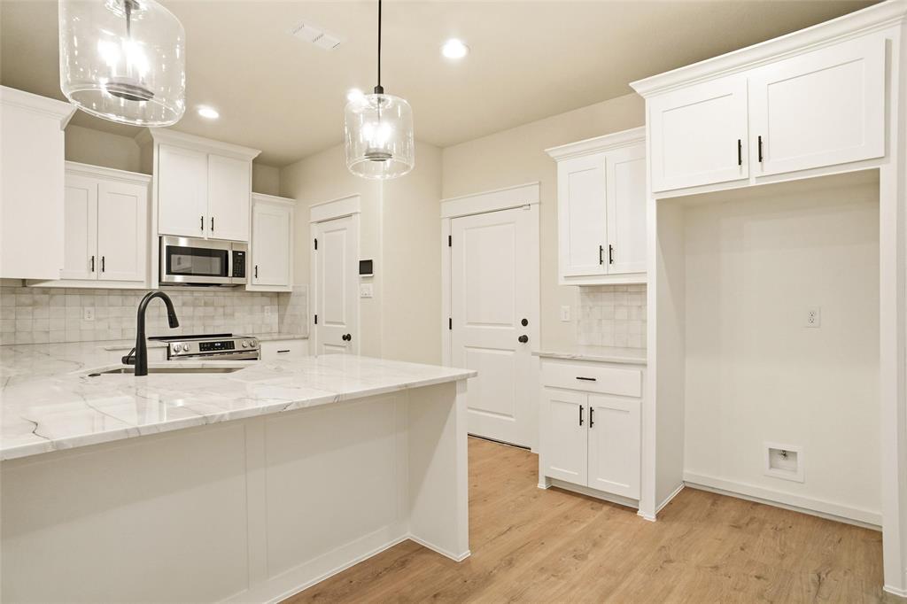 206 Legacy Boulevard Weatherford, TX 76086 - Photo 6 of 21 a large kitchen with cabinets stainless steel appliances and a counter space