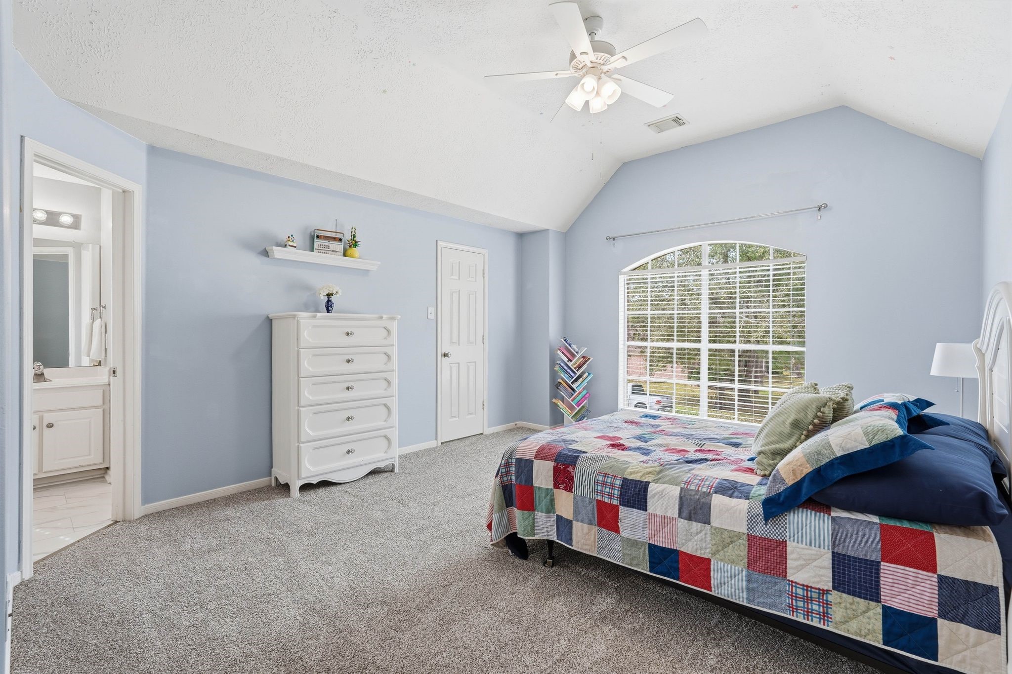 2515 Woodsboro Drive Spring, TX 77388 - Photo 30 of 44 Spacious secondary bedroom with soft blue walls, featuring a large window for natural light. Includes a walk in closet and ensuite bathroom.
